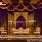 "Arabic theme golden open door style wedding stage backdrop with laser-cut panels, purple and gold drapery, royal sofa and chairs, and floral decorations – luxury wedding stage setup UK."