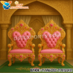 “Maharaja Style Bride and Groom Wedding Chairs – Golden carved wooden thrones with pink fabric tufted upholstery, designed for royal wedding stage seating.”