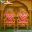 “Maharaja Style Bride and Groom Wedding Chairs – Golden carved wooden thrones with pink fabric tufted upholstery, designed for royal wedding stage seating.”