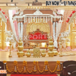 Grand Southern wedding stage setup with golden mandap, white elephant arch pillars decorated with flowers, and pink-golden drapes — perfect for traditional South Indian marriage ceremonies.