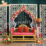 Modern geometric white laser-cut panels used as a wedding and event backdrop with floral decorations, yellow bench seating, and elegant stage decor by DST International.