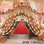 Grand Southern wedding stage setup with golden mandap, white elephant arch pillars decorated with flowers, and pink-golden drapes — perfect for traditional South Indian marriage ceremonies.