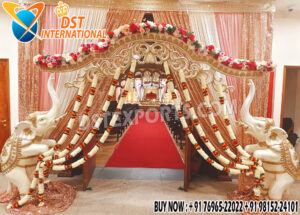 Grand Southern wedding stage setup with golden mandap, white elephant arch pillars decorated with flowers, and pink-golden drapes — perfect for traditional South Indian marriage ceremonies.
