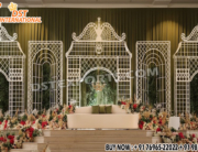 “Trendy geometric metal backdrop frames for grand wedding reception stage with floral decor and arch design by DST International”