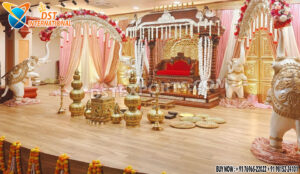 Grand Southern wedding stage setup with golden mandap, white elephant arch pillars decorated with flowers, and pink-golden drapes — perfect for traditional South Indian marriage ceremonies.