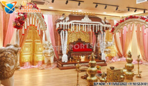 Grand Southern wedding stage setup with golden mandap, white elephant arch pillars decorated with flowers, and pink-golden drapes — perfect for traditional South Indian marriage ceremonies.